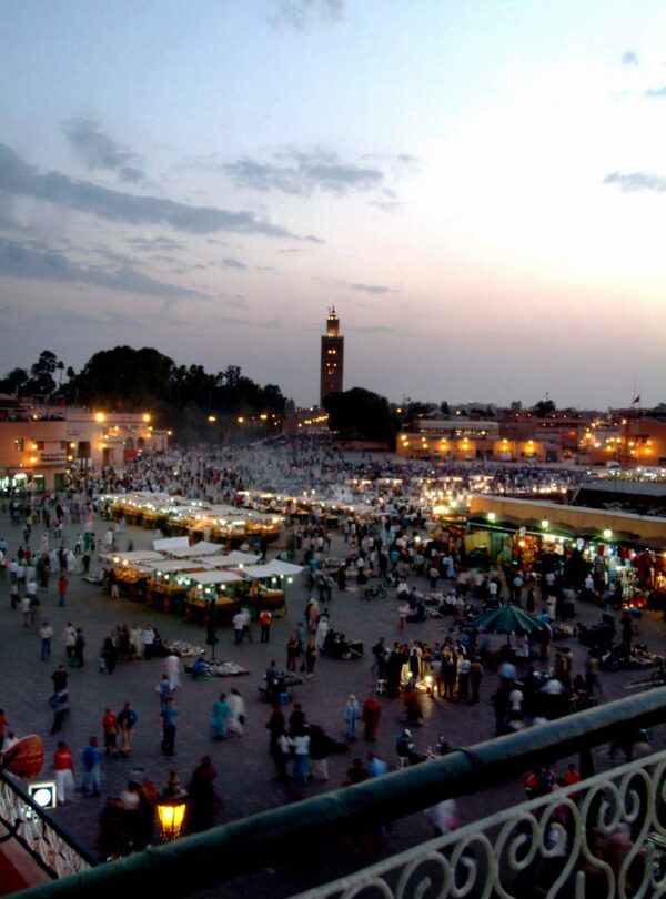 Vibrant market scene at Jemaa el-Fnaa with minaret and crowd during sunset in Marrakech. Morocco itinerary 7 days .morocco travel