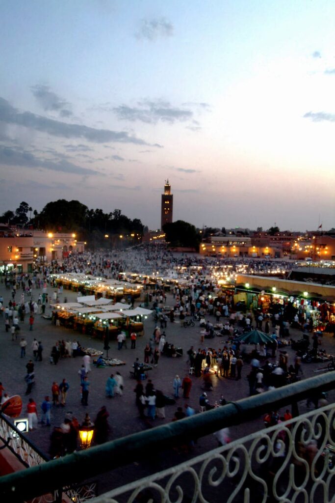 Vibrant market scene at Jemaa el-Fnaa with minaret and crowd during sunset in Marrakech. Morocco itinerary 7 days .morocco travel
